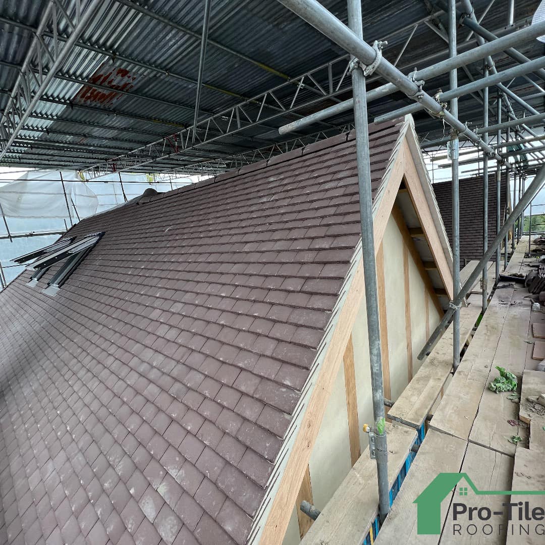 Plain tiles laid on hipped roof with scaffold