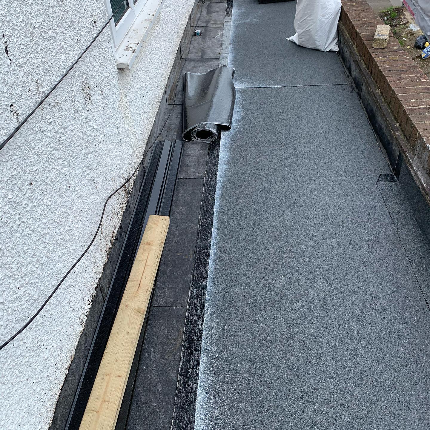 Torch-on felt flat roof installation in progress